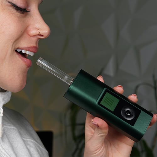 Woman in the process of using the Arizer Solo 3 vaporizer.