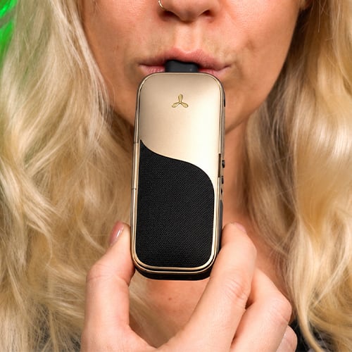 Woman in the process of using the AirVape Legacy Core vaporizer.