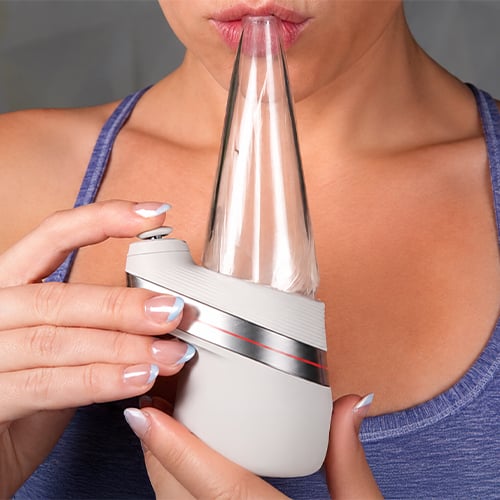 Woman inhaling from Puffco Peak with the glass mouthpiece
