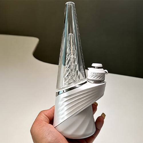 Woman holds up a Puffco Peak Pro 3DXL from the silicone base