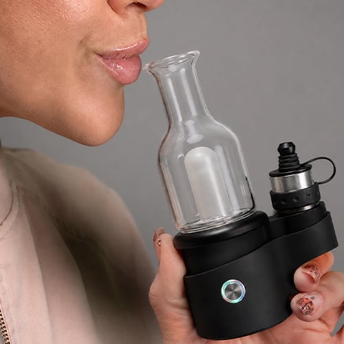 Woman getting ready to inhale from The Core 2.1's glass mouthpiece