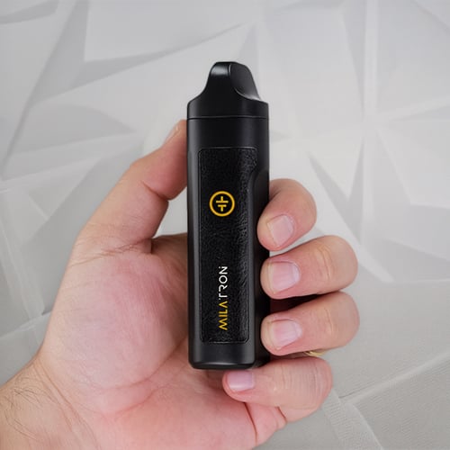 Hand holding a Tronian Milatron vaporizer.
