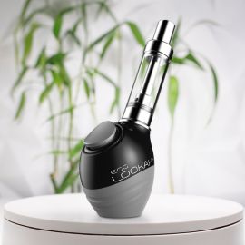 Une batterie Lookah Egg à filetage 510 posée sur une surface circulaire blanche avec un fond flou de plante verte.