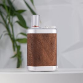 Vaporisateur Tinymight 2 avec un corps en bois élégant, des accents métalliques et un embout buccal en verre, sur un fond doux.