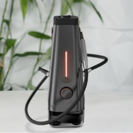 AirVape Enso desktop vaporizer with glowing orange LED bar and attached hose, front view on a modern indoor background.