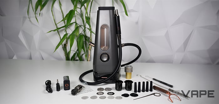 Complete AirVape Enso 2026 kit laid out on a white table: the electric shisha with coiled vapor hose, USB-C charger, spare ceramic cups, disposable aluminum cups, mesh screens, blowout valves, wooden mouthpiece stem, cleaning brushes, and multi-tool